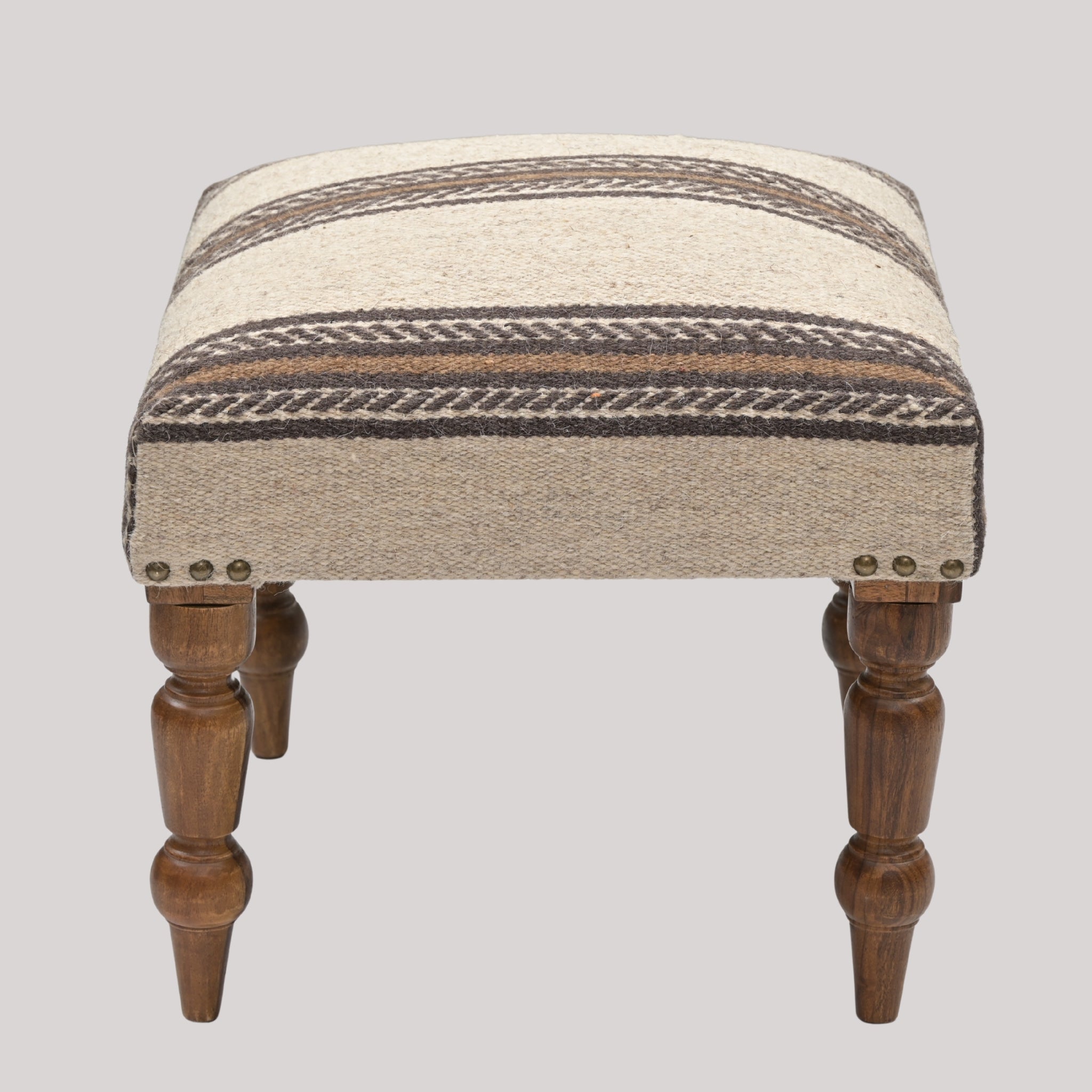 Wooden stool with patterned cushion on a gray background