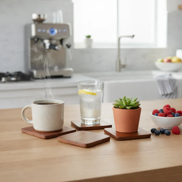 Terra Square Wooden Coasters with a mug, glass, and potted plant on a kitchen counter.