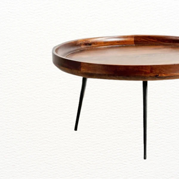 Raised edge detail of round mango wood coffee table to prevent items from slipping